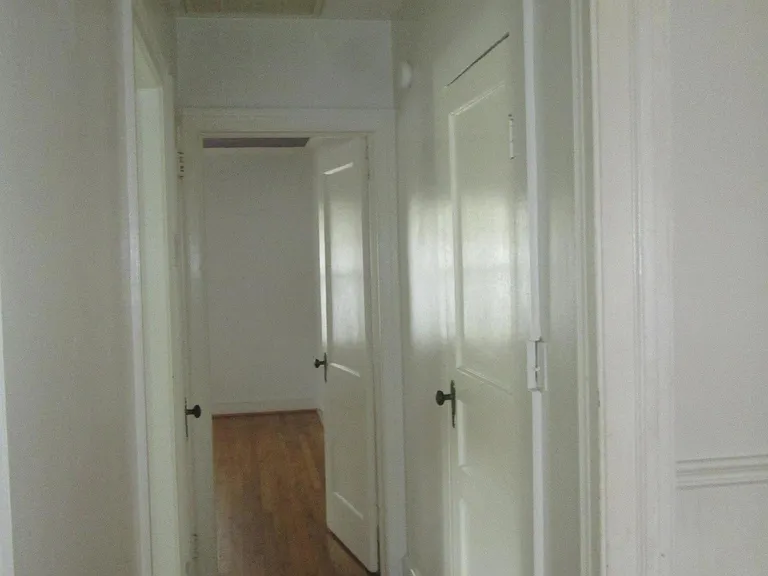 Hallway with bathroom and two bedrooms, on either end