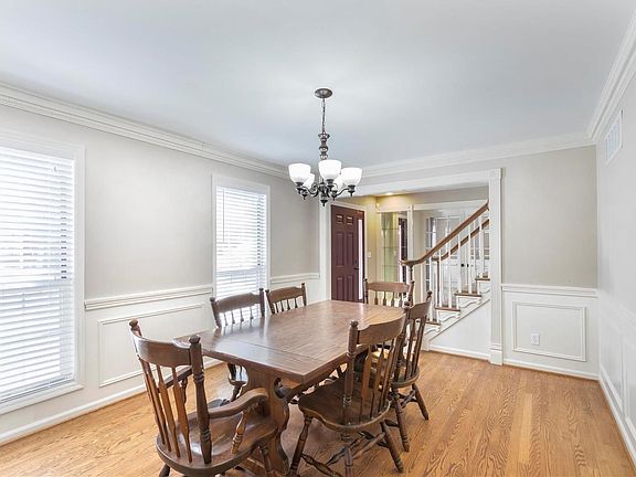 Separate Dining Room with hardwood flooring, wainscoting, beautiful moldings