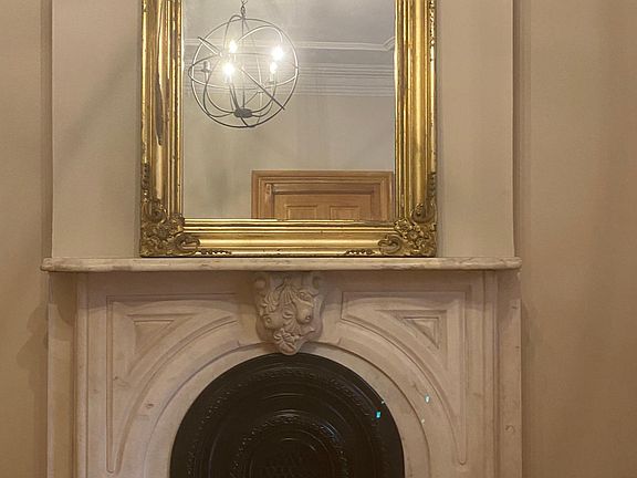 Living room, brownstone shutters, marble fireplace, gilt mirror