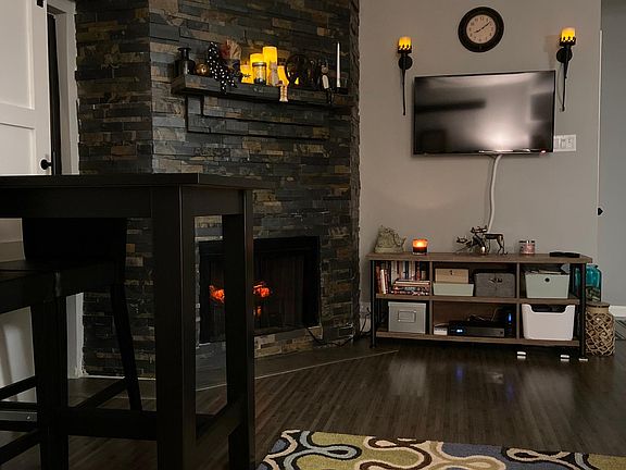 Living room area (view from the couch); bar dining table with two (2) chairs.