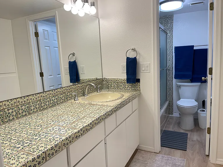 Secondary bedroom's en suite bathroom with separate vanity area