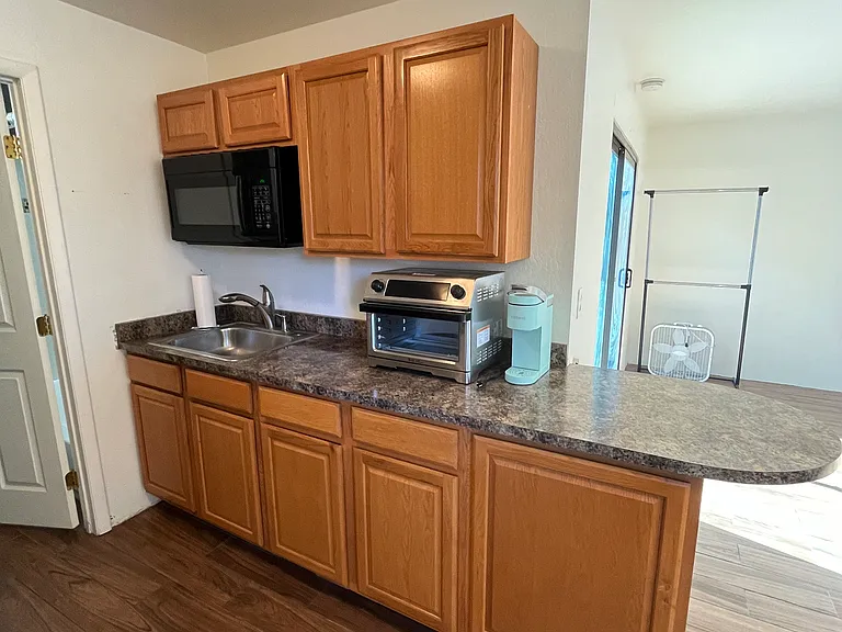 kitchen includes: microwave, sink, convection/toaster/air fryer, countertop burner (not pictured), Keurig, full-size fridge
