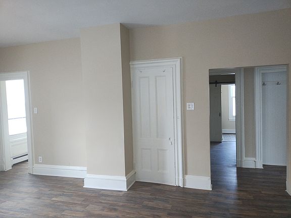 View from living room. On left, hallway leading to Bedroom 1. On right, entry hall/hallway leading to bathroom.