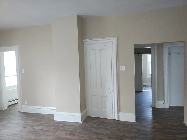 Living room. View of hallway leading to first bedroom on left. View of hallway leading to bathroom and second bedroom on right.