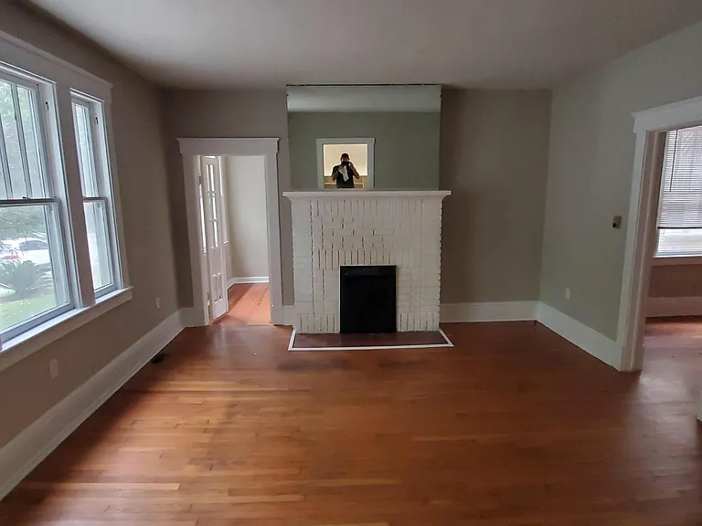 Living room with french door entrance to sunroom/potential 3rd bedroom by fireplace