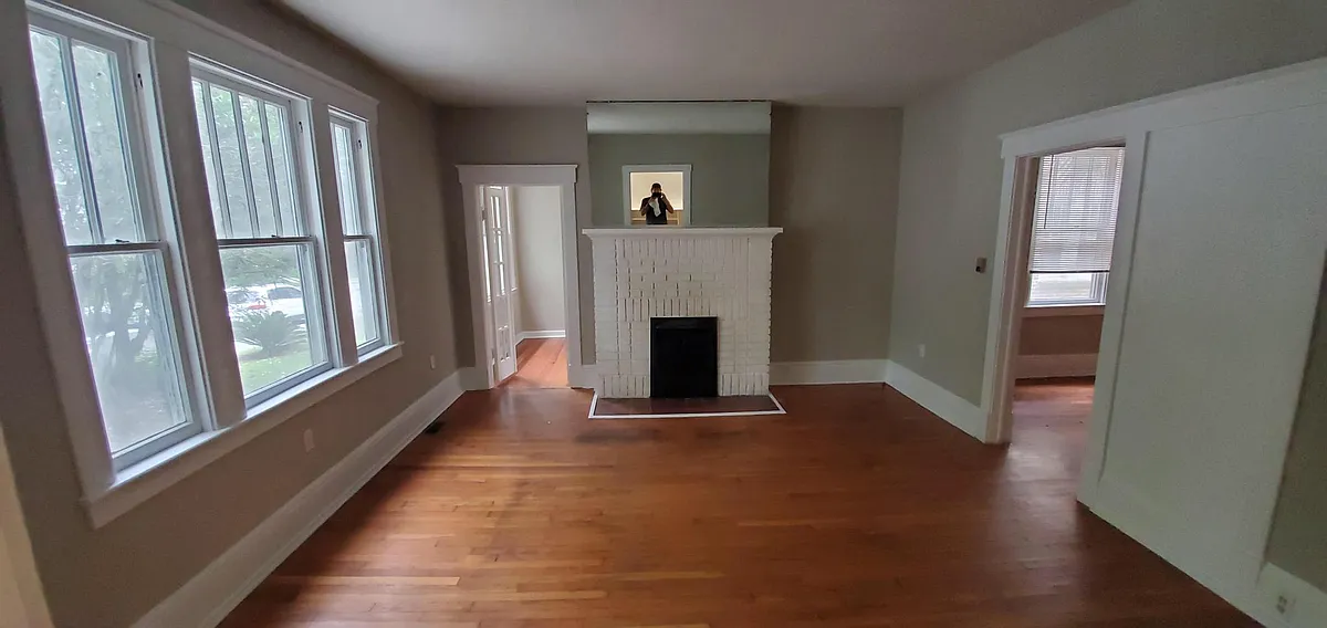 Living room with french door entrance to sunroom/potential 3rd bedroom by fireplace - 619 E 48th St #B