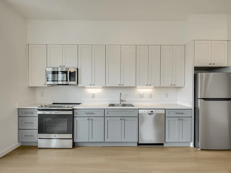 Modern kitchen with stainless steal appliances and quartz counters