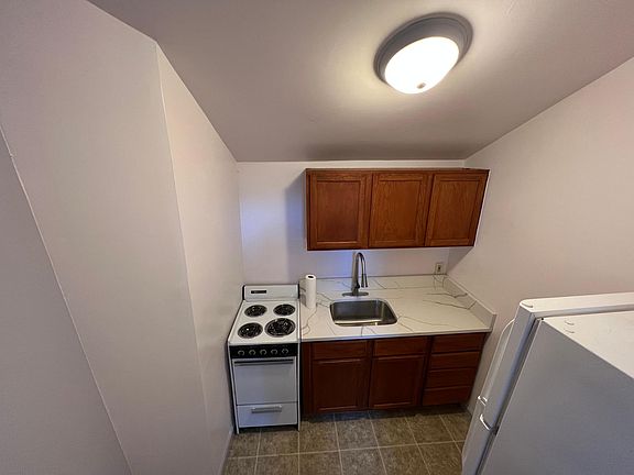 The kitchen is small but updated and functional with real wood cabinets and new quartz countertops.