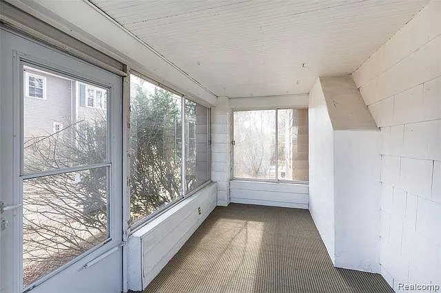 Fully enclosed front porch with windows.