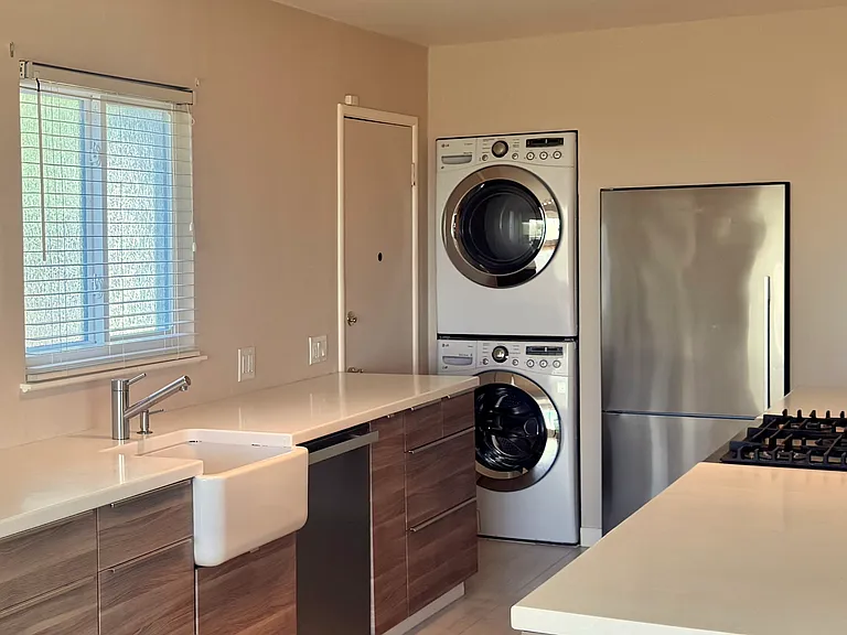 Amenities include a stacked, high-capacity LG front-loading washer and dryer and a stainless Fisher Paykel bottom freezer refrigerator.