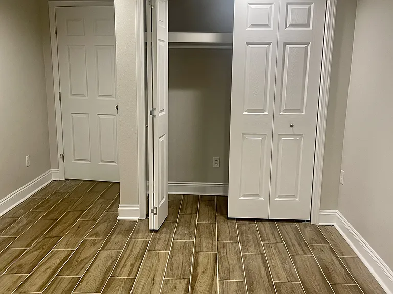Spacious guest bedroom (1/4) with a closet and convenient outdoor access to the carport area.