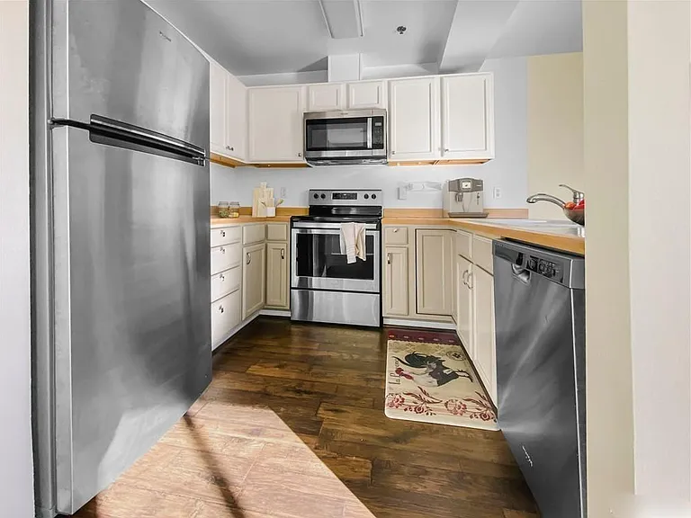 Large, updated galley kitchen with new appliances including microwave and vented range hood.