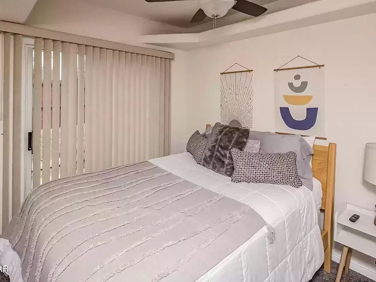 Bedroom 2 on main level with queen bed and walk-in closet.