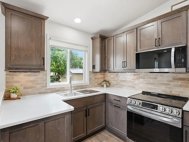 Full kitchen on upper level w/ custom cabinetry, SS appliances, quartz countertops, tile backsplash & in-sink dishwasher!