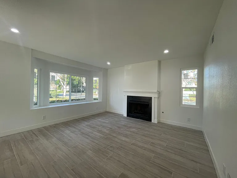 living room with gas fireplace and bay window