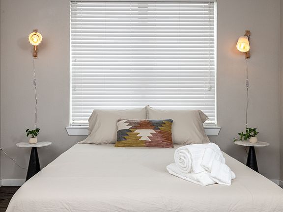 Inviting fourth bedroom with a queen bed and soft hanging lights on each side_simple, stylish, and made for a peaceful night's sleep. This bedroom is located upstairs.