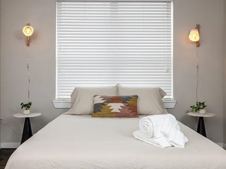 Inviting fourth bedroom with a queen bed and soft hanging lights on each side_simple, stylish, and made for a peaceful night's sleep. This bedroom is located upstairs.