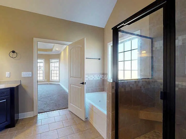 Elegant spa-like master bath featuring a jacuzzi soaking tub, expansive tiled shower, and premium vanity.