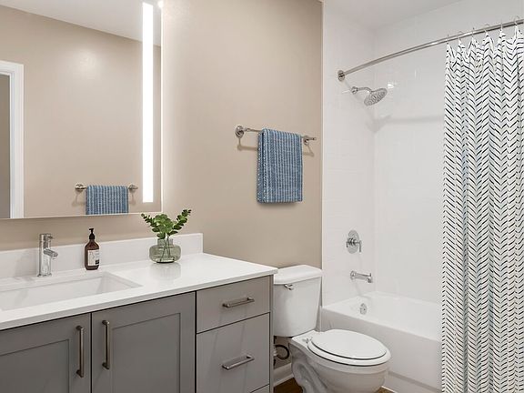 Signature Collection bath with grey cabinetry, white marbled quartz countertops, and hard surface flooring