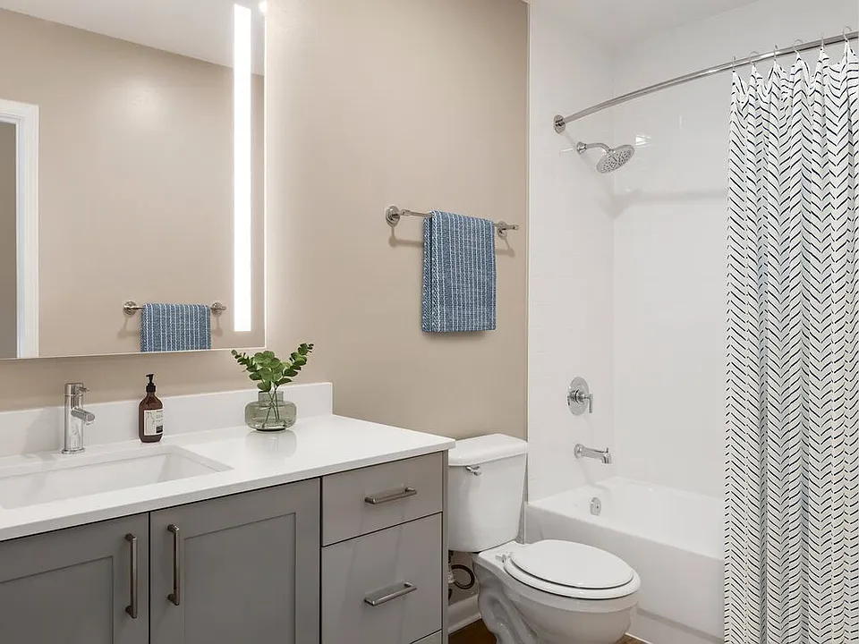 Signature Collection bath with grey cabinetry, white marbled quartz countertops, and hard surface flooring