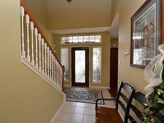 Elegant entry offering a beveled glass front door, tile flooring, two story high ceilings and access