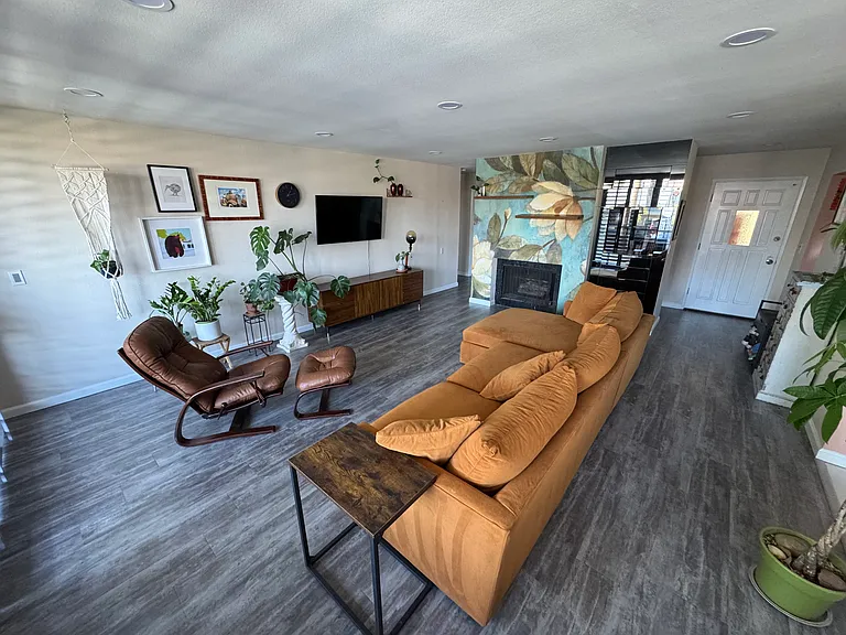 Living Room facing toward fireplace and wall bar. Dining area to viewer's back.