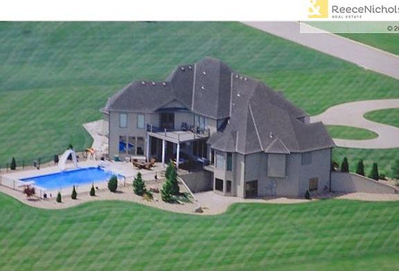 Aerial view of the back of the house with the large heated salt water pool, walk out basement and almost 4 acre  yard. Circle drive welcomes visitors in front of the house with additional parking on the side.