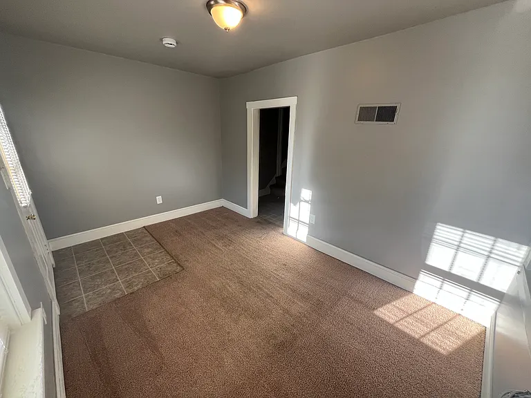 Living room, front entrance to the left, kitchen to the right.
