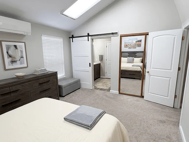 main bedroom with mini-split ac/heating unit, ceiling fan