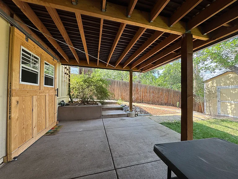 Outdoor entertainment or other space under deck - newer concrete and sheltered with water tight aluminum deck above.