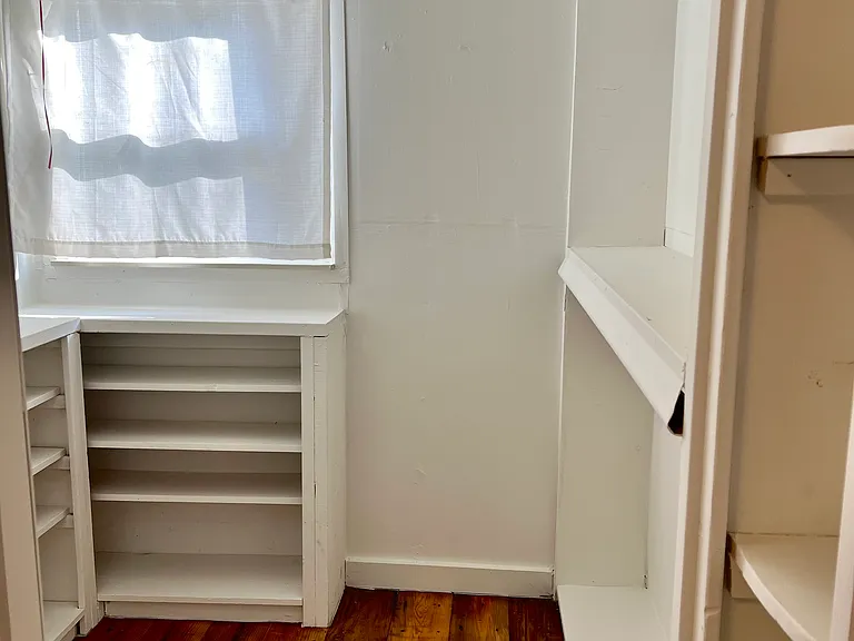 Walk in closet with lots of shelving and storage
