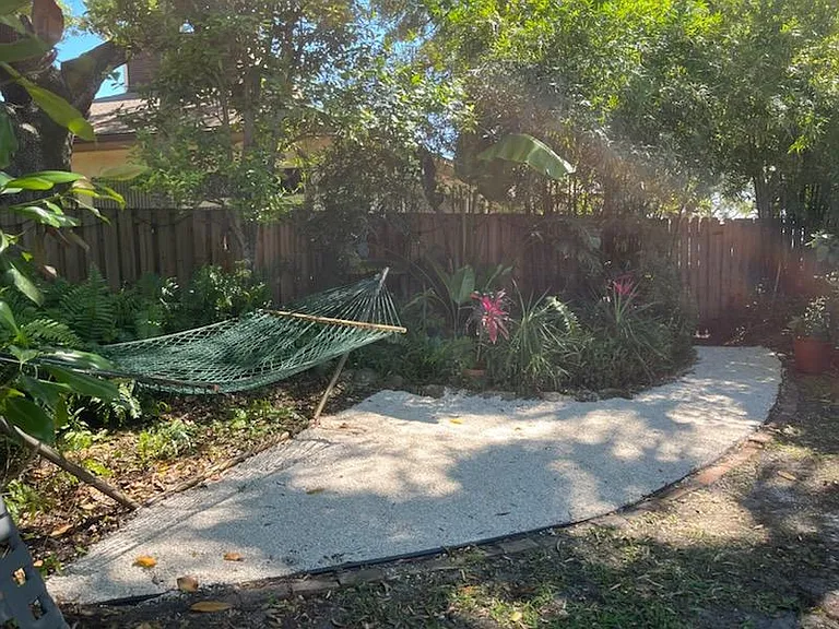 Two person hammock and clean shell walkway leading to back fence gate.