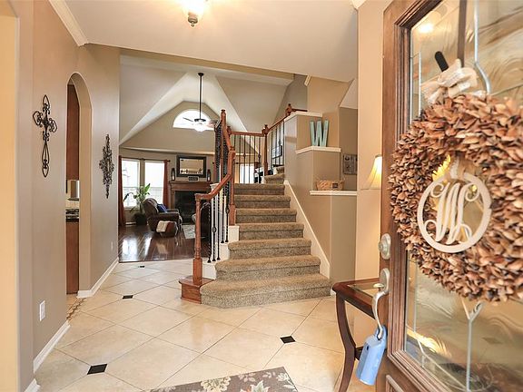 Enter to the foyer with tile flooring with granite insets. Side placed staircase with newer carpet. Neutral paint.