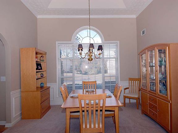 Frml dining rm w/extra-high ceiling, archways, & wall of windows