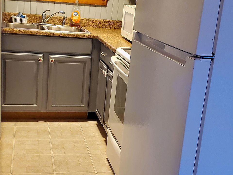 Compact kitchen with ample counter space, upper/lower cabinets, and a full appliance set including fridge and range.