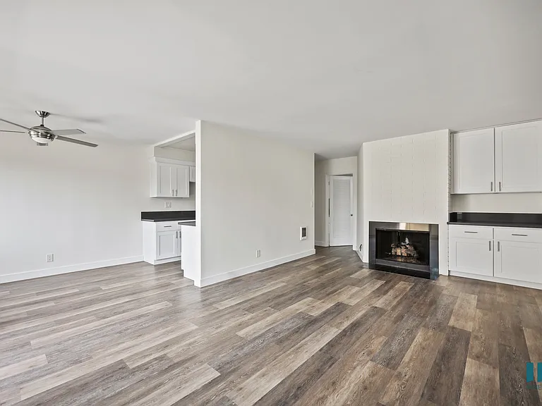 Open-Concept Dining and Living Room with Fireplace, Built-In Cabinets, and Vinyl Flooring