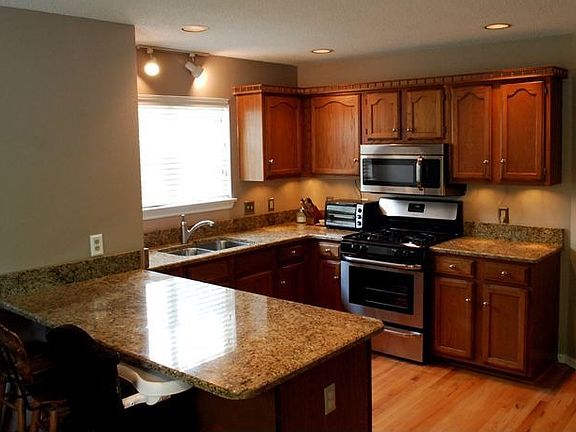 kitchen with granite counters, bar, and stainless appliances
