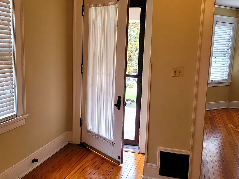 Front entry door is beveled glass with storm door in front