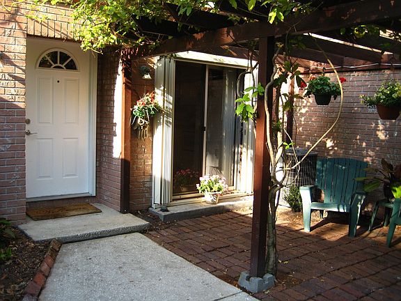 Private entry with brick patio and arbor