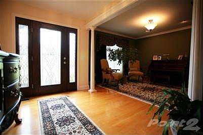 View back to the front doors.  The hardwood floors and dark stained entry doors give the home a classic but elegant look and feel.