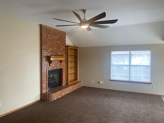 Living room and dining area have vaulted ceilings. There is a gas insert, which provides back-up heat during ice storms. Note the extra large ceiling fan.