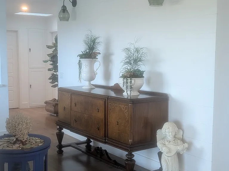 Coastal chic hallway: vintage sideboard under shiplap wall.
