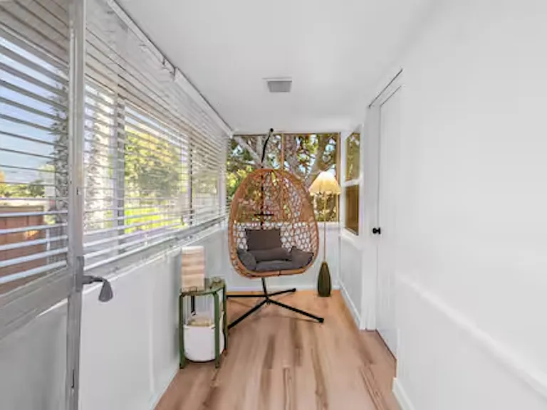 Sunroom accessible directly from bedroom with bunk beds, providing a bright, relaxing space to unwind and step out to the outdoor area.