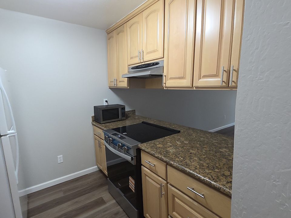 Galley Style Kitchen with new Dishwasher and Range, featuring maple cabinetry and granite countertops