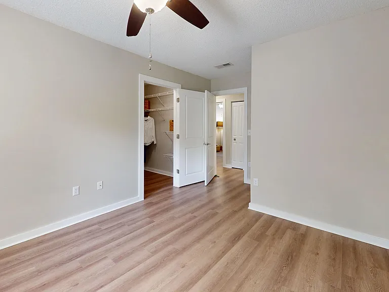 Unwind in the Jekyll master bedroom with elegant wood-styled floors and enjoy the vast walk-in closet adorned with customized shelving.