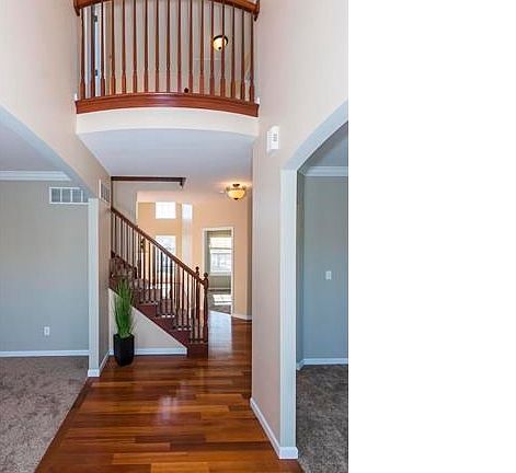 2-Story Entry with gorgeous Brazillian Cherry Wood floors in entry, hall, kitchen and breakfast rooms.  Radius balcony rail above.  Formal Dining Room to left and Living Room to right.  New carpet.