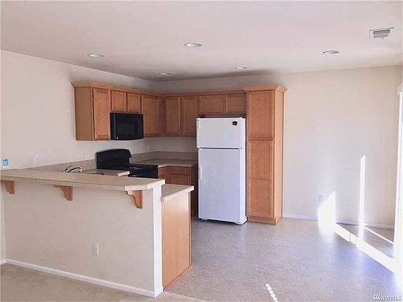 Kitchen with eating bar and table eating area.