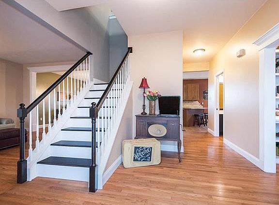 Large entry w/ Hardwood floors.  Wood stairs lead upstairs to flex room and four bedrooms.  Private office is to the right and features custom built in shelves with lighting.  Half bath is second door on the right.  Beyond is the Kitchen, Dining and Famil