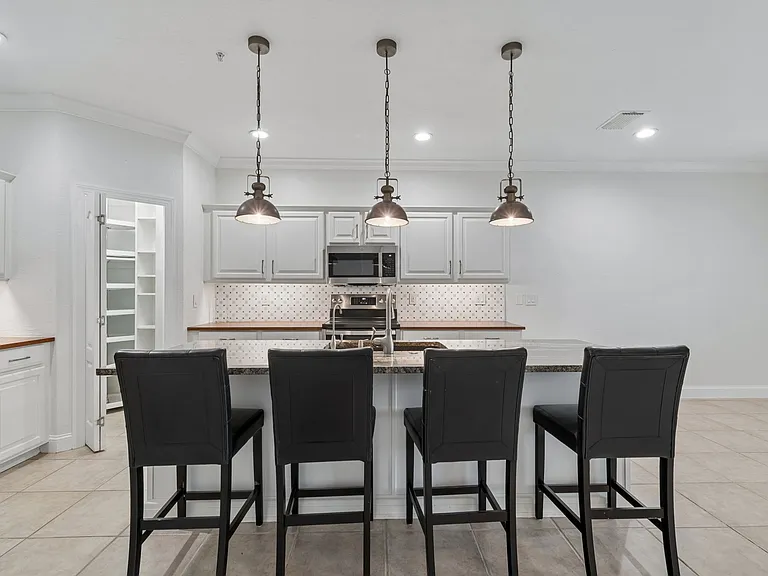 This upscale, gourmet kitchen features high-end finishes, including natural granite countertops and elegant butcher block accents, all complemented by a built-in reverse osmosis water filtration system.