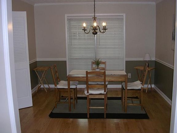 The dining room features chair railing, hardwoods and a view to living room.